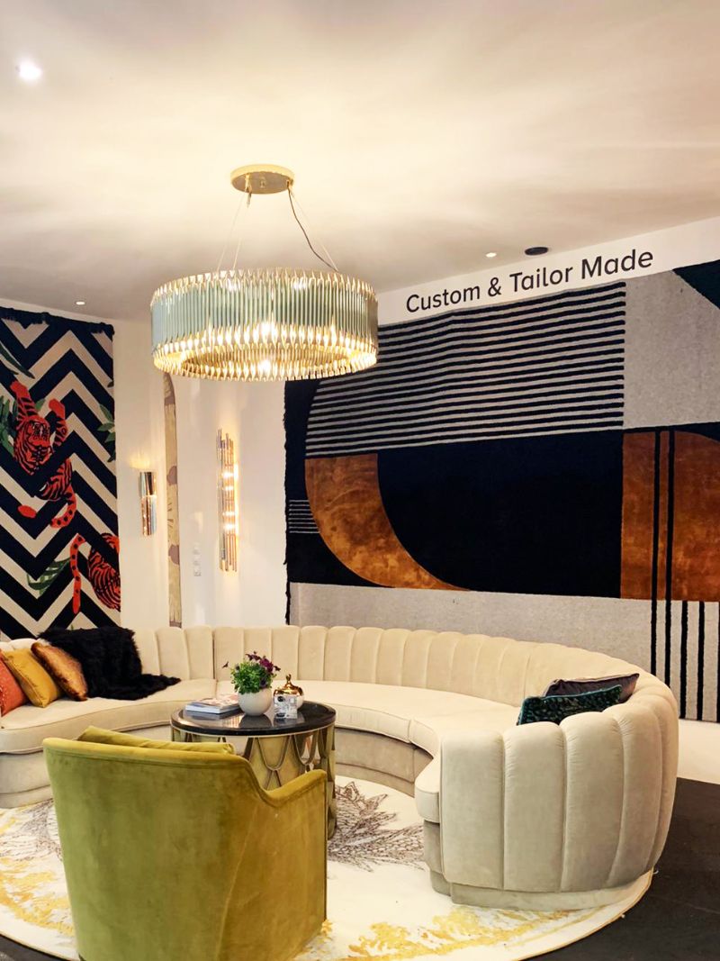 iSaloni 2022: A Practical Guide For The Fair. A contemporary living room with wall rug decor and round rug on the floor. A curved sofa and armchair style the room too.