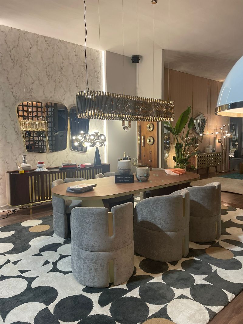 isaloni 2022: mid-century dining room with modern rug and gray circular dining chairs and golden suspension lights