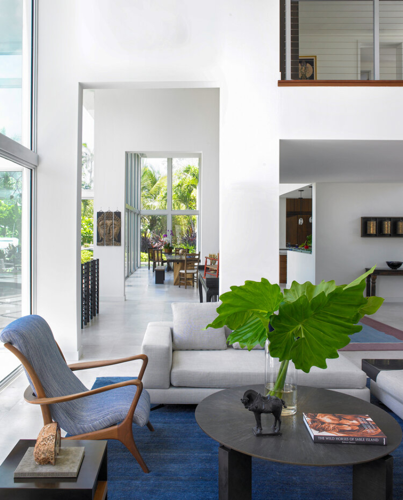 Michael Wolk - Fort Lauderdale Residence. Living room with a blue rug, blue armchair ang grey sofa.