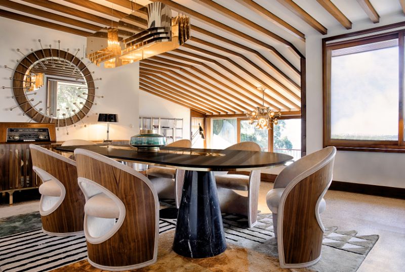 midcentury dining room with colorful SIMBA RUG, oval dining table and round mirror What Are The Best Modern Hand-Tufted Dining Room Rugs?