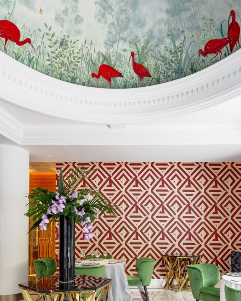 green dining chairs, red and white wall, golden side tables