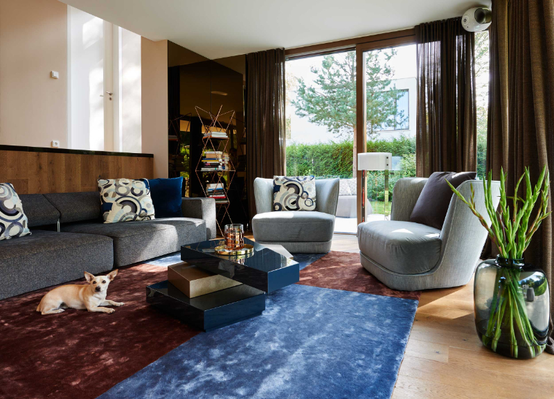 Raumkonzepte Peter Buchberger, cubist Style Villa living room with a colourfull rug, 2 grey armchairs, ne sofa and a center table