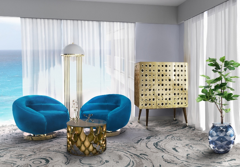 Rug Design Inspiration by Camden Lane Interiors. This seating area has two blue armchairs, a gold cabinet, a gold floor lamp, a gold coffee table and a rug in grey with blue lines.