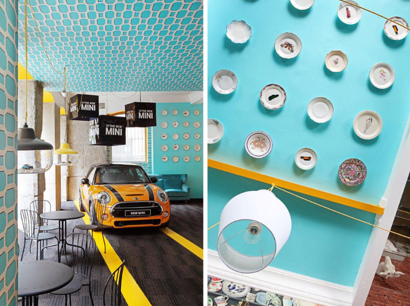 Restaurant by Guille García Hoz with black tables and chairs, yellow mini cooper and decorative elements in the celing